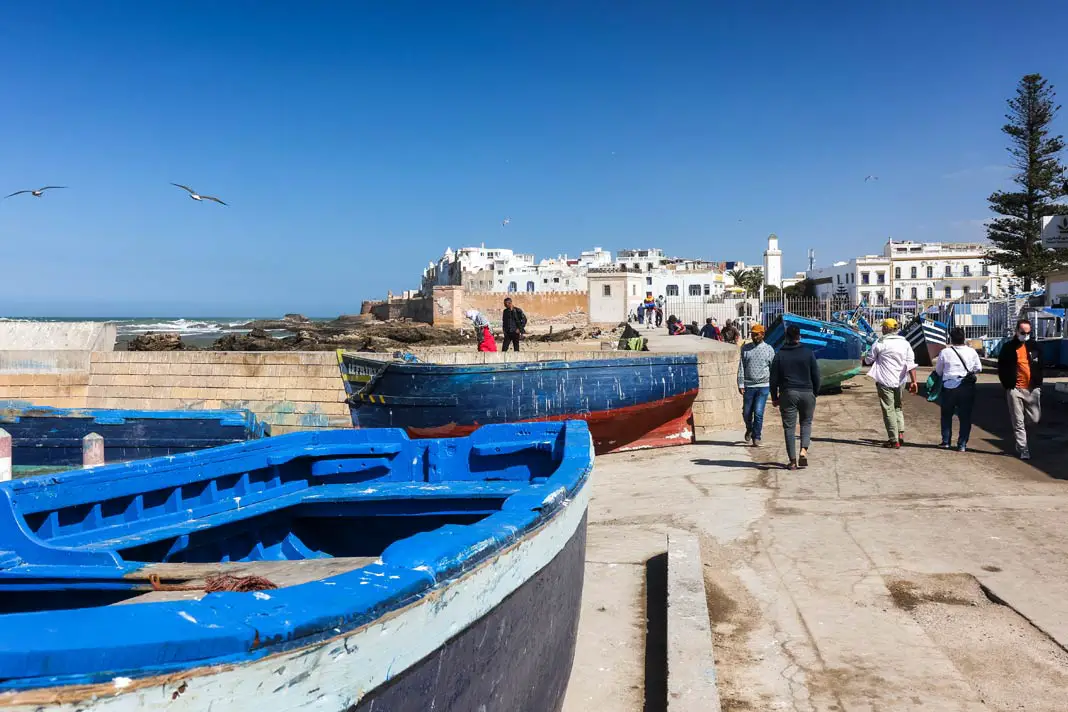 Blaue Schiffe direkt am Wasser vor der Stadt Essaouira in Marokko