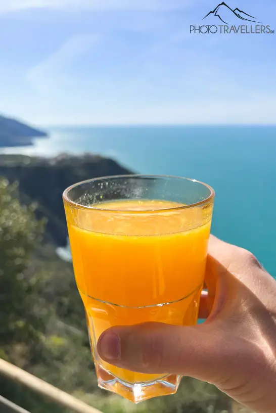 Ein Glas Orangensaft mit Blick aufs Meer