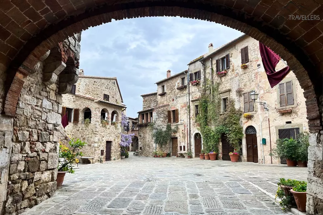 Ein Torbogen mit Blick auf einen schönen Platz in Montemerano