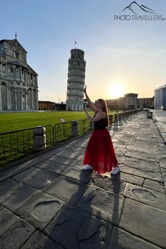 Reisebloggerin Biggi Bauer, wie sie gegen den Schiefen Turm von Pisa drückt