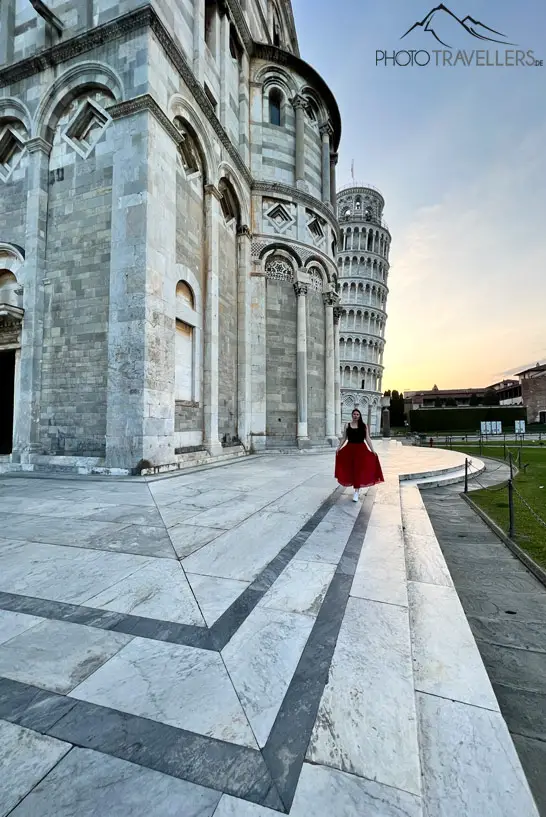 Biggi in einem roten Kleid am Morgen am Schiefen Turm von Pisa