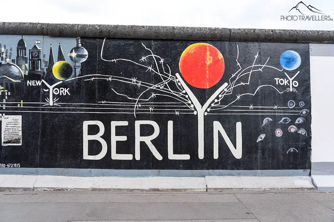 Ein Teil der Berliner Mauer an der East Side Gallery. Abgebildet sind die Schriftzüge New York, Berlin und Tokyo auf schwarzem Grund