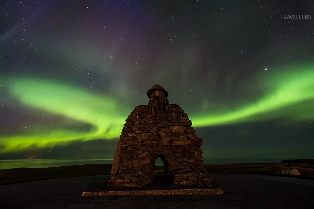 Der Steintroll an der Küste von Arnarstapi auf Island mit Nordlichtern