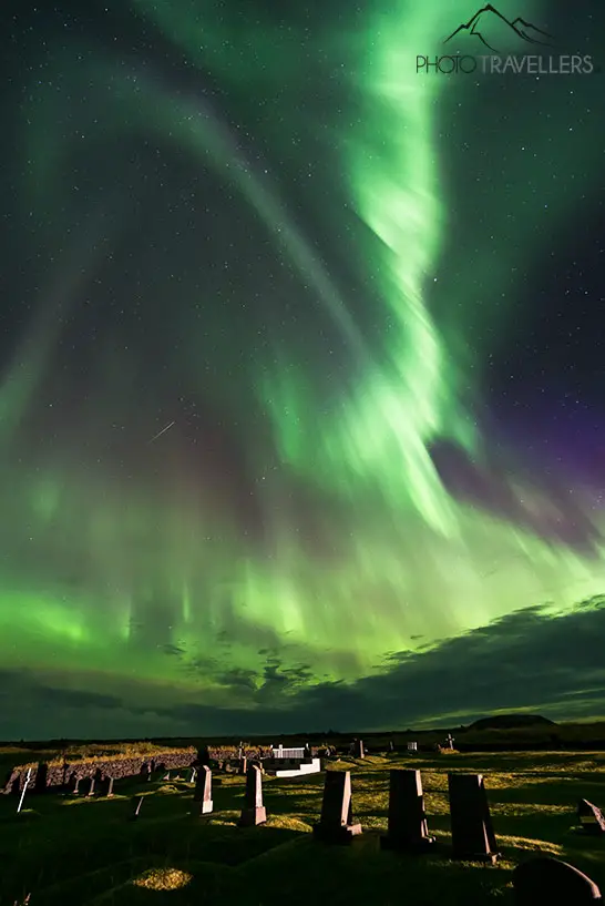 Bright northern lights over the Búðakirkja cemetery in Iceland