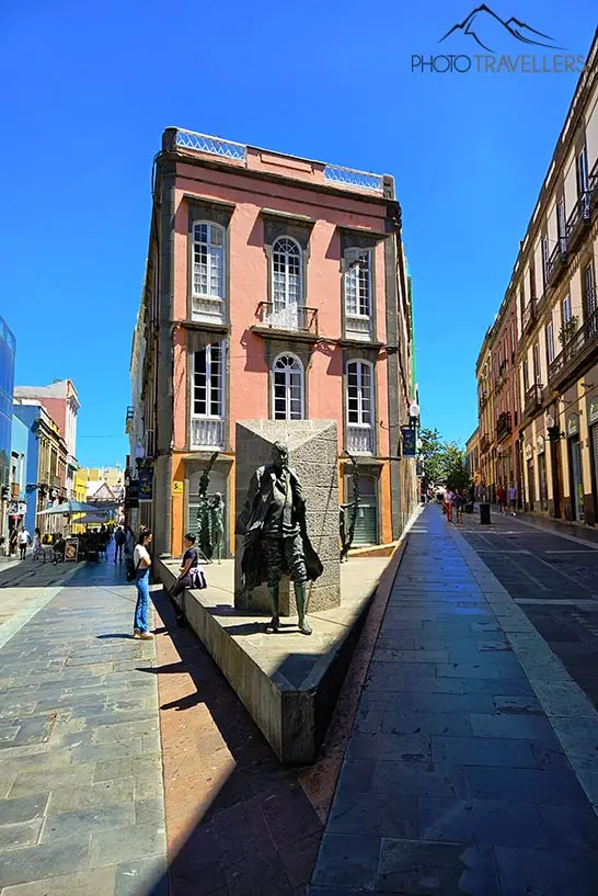 Die Skulptur eines steht vor einem rosafarbenen Haus in der Altstadt von Las Palmas 