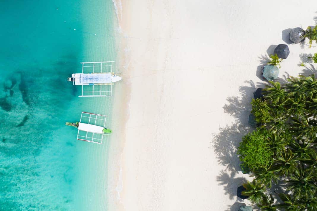 Ein Strand auf der Insel Daku mit zwei Booten aus der Luft