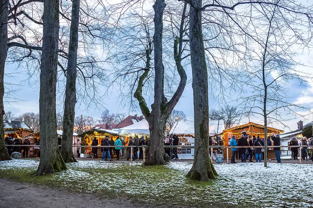 Blick durch Bäume auf den Christkdindlmarkt auf der Fraueninsel im Chiemsee in Oberbayern