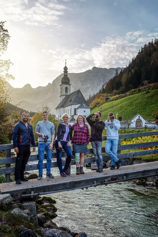 Teilnehmer unseres Fotokurses in Bayern vor einer Kirche in den Alpen
