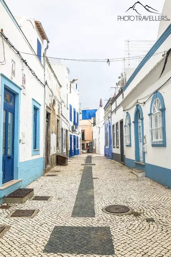 Blick in eine Gasse mit weiß-blauen Fischerhäusern von Olhao