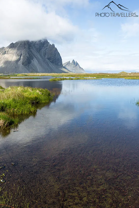 Ein Berg spiegelt sich im Wasser auf der Landzunge Stokksnes
