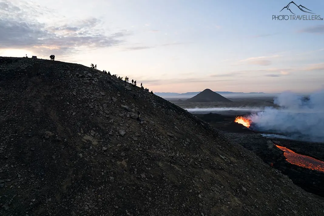 Menschen auf dem Gipfel des Litli-Hrútur mit Blick auf den Vulkanausbruch