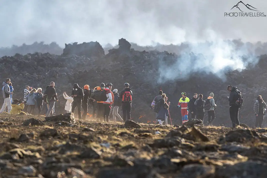 Menschen vor der Lava des Vulkanausbruchs in Island