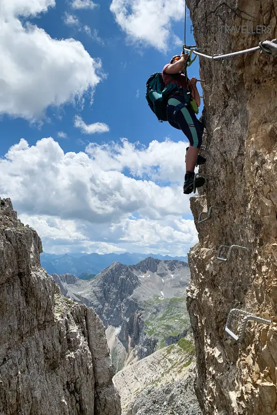Reisebloggerin Biggi Bauer auf Stufen in einer Felswand auf dem Latemartürme-Klettersteig