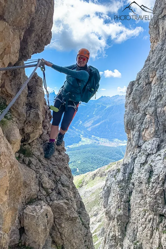 Reisebloggerin Biggi Bauer hängt an einer luftigen Stelle am Masaré-Klettersteig in den Dolomiten