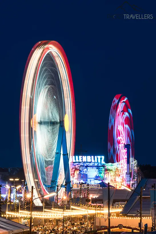Eine Langzeitbelichtung in der Nacht vom Riesenrad auf dem Münchner Oktoberfest