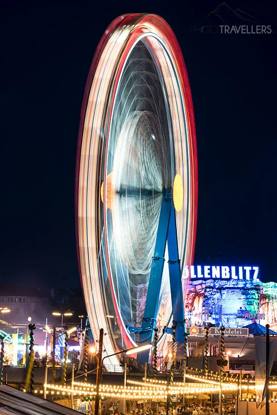 Eine Langzeitbelichtung in der Nacht vom Riesenrad auf dem Münchner Oktoberfest