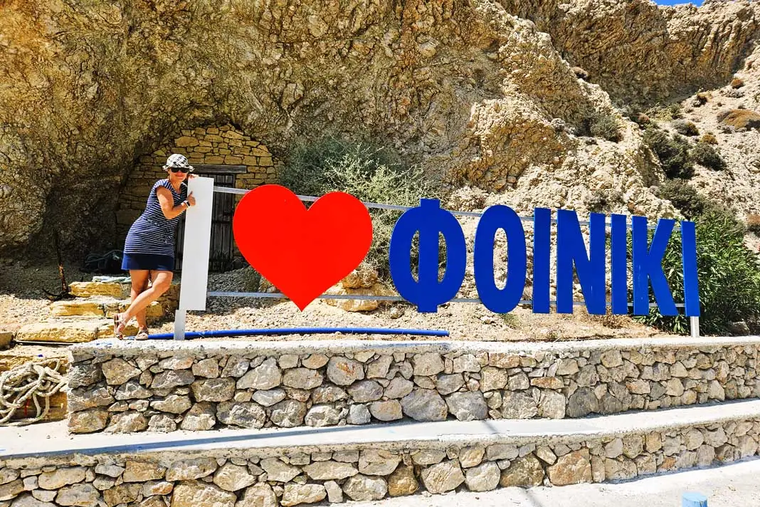 Eine Urlauberin am "I love Finiki"-Zeichen in Finiki auf Karpathos
