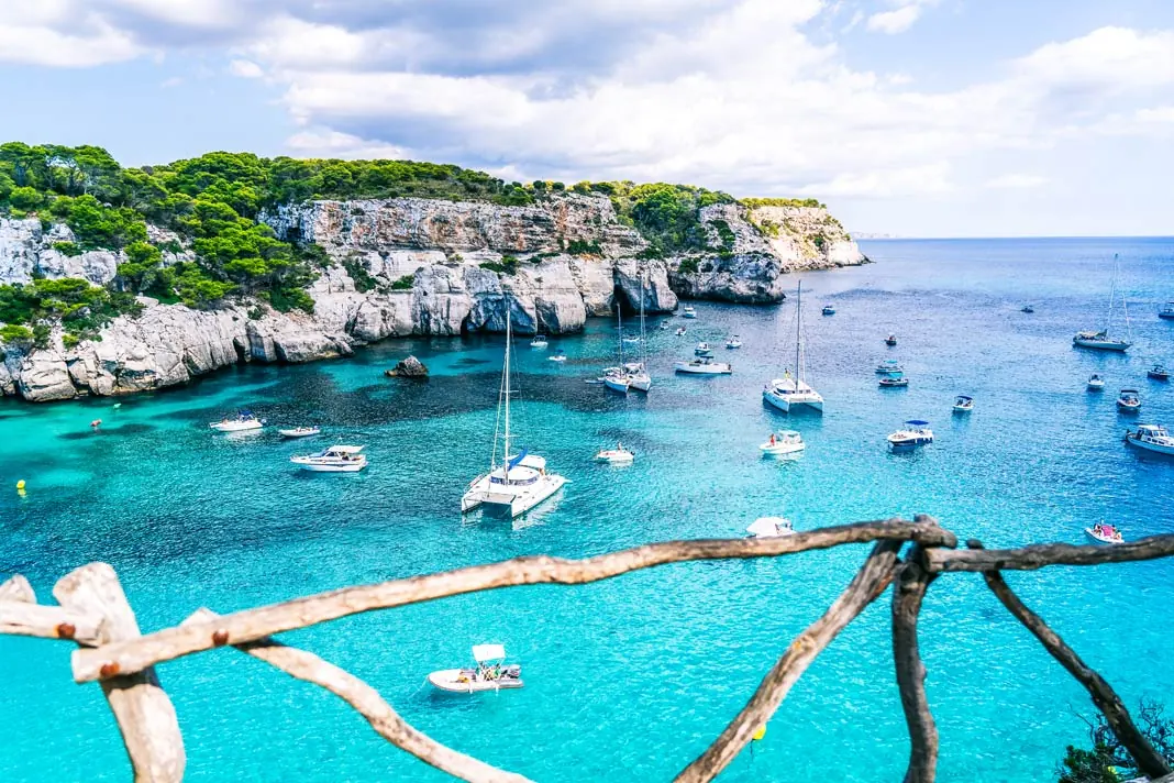 Blick auf die bekannte Bucht von Cala Marcarelleta auf Menorca mit einigen Booten, die vor der Bucht ankern