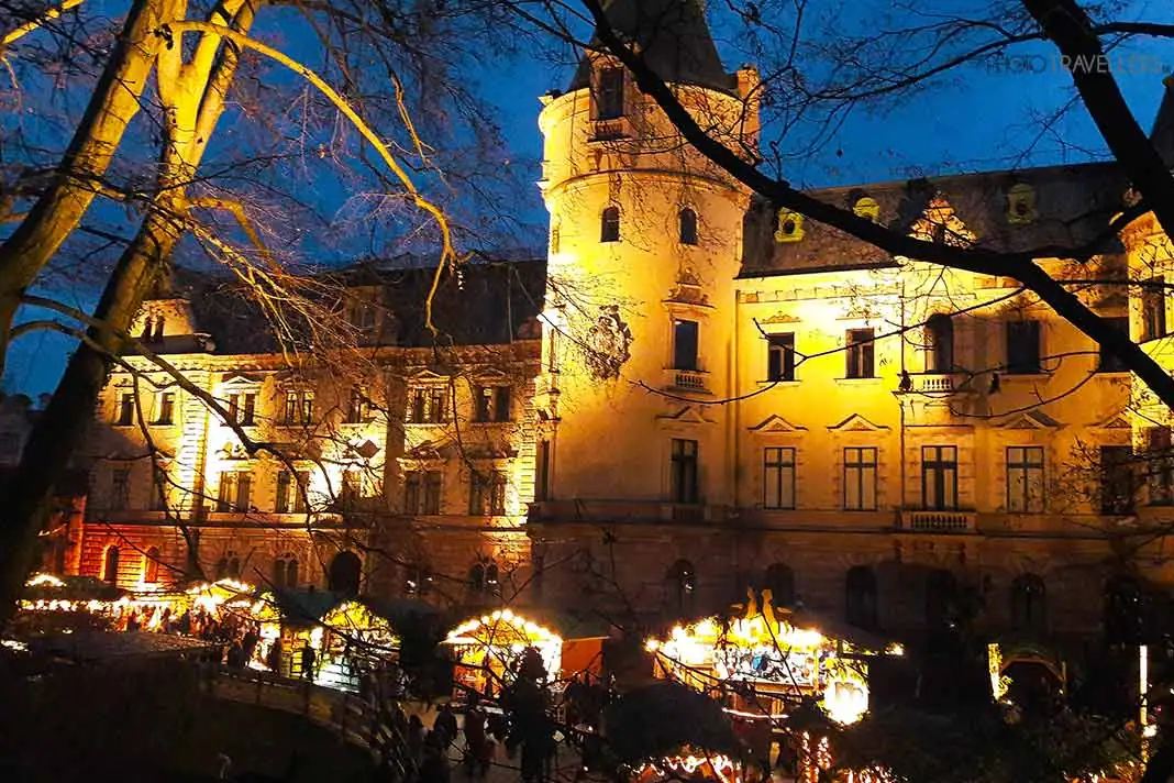 Weihnachtshütten vor der beleuchteten Fassade von Schloss Thurn und Taxis