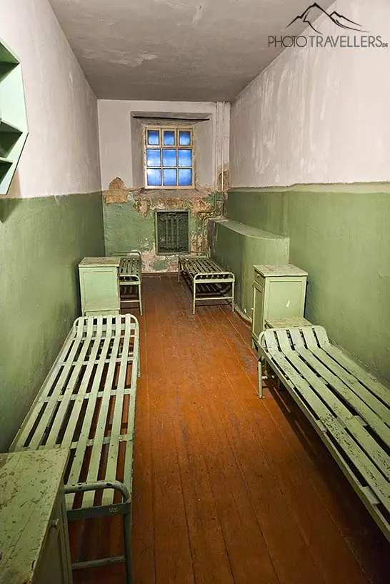 Grüne Pritschen stehen sind aufgereiht in einer Zelle des ehemaligen KGB-Gefängnisses