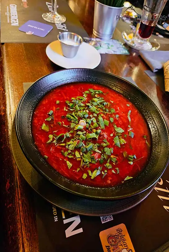 Rote Suppe mit Kräutern garniert in einem Teller serviert