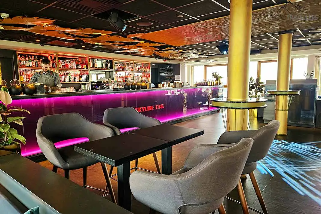Tische und Stühle vor der violett beleuchteten Tresen der Skyline Bar in Riga