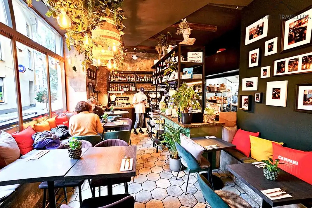 Nur wenige Gäste sitzen an den Plätzen eines kleinen Cafés in Riga
