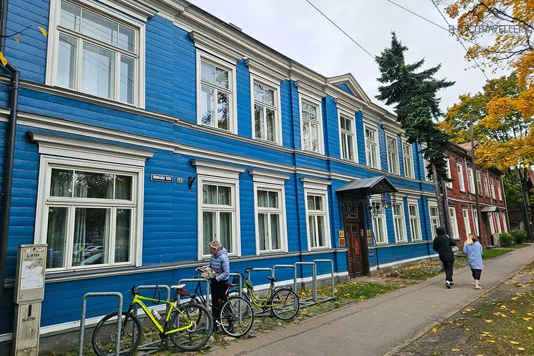 Fahrräder stehen vor einem großen blauen Holzhaus in Riga
