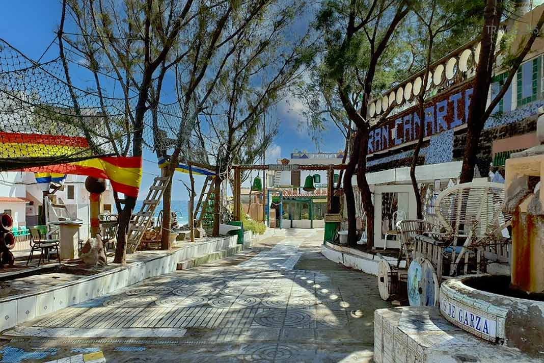 Ein schmaler Weg führt durch das mit Bäumen bewachsene Fischerdorf Playa de Ojos de Garza