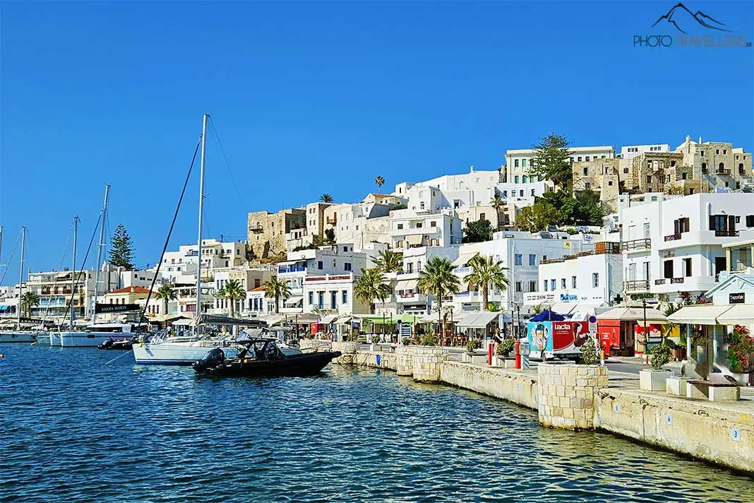 Ein kleines Boot ankert vor der dichtbebauten Chora von Naxos