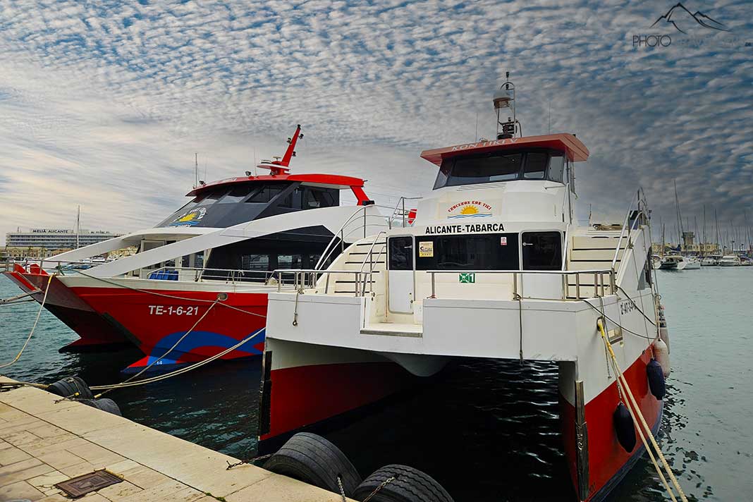 Zwei Katamarane mit rot-weißer Lackierung ankern im Hafen