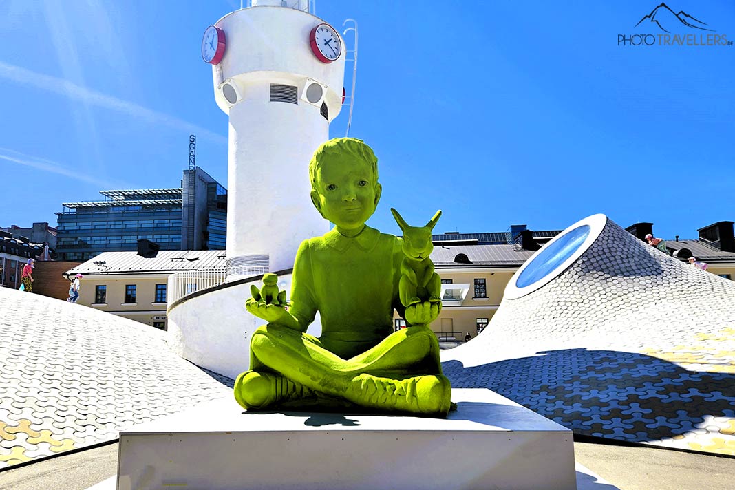 Die Skulptur mit dem übergroßen knallgrünen Jungen ziert den Hof des Museums Amos Rex