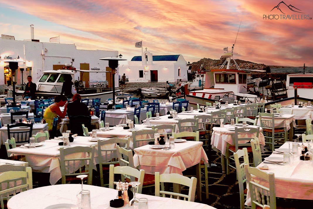 Die Tischreihen im Hafen von Naoussa auf Paros füllen sich zum Sonnenuntergang allmählich