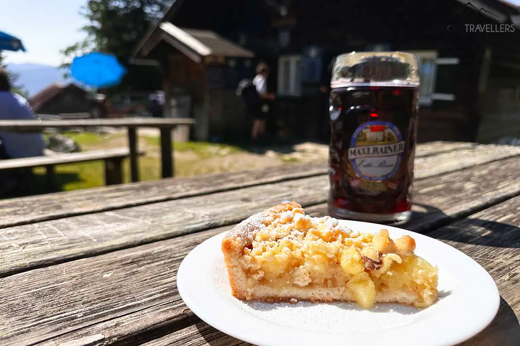 Ein Apfelkuchen und eine Saftschorle auf einem Tisch vor der Hubertushütte