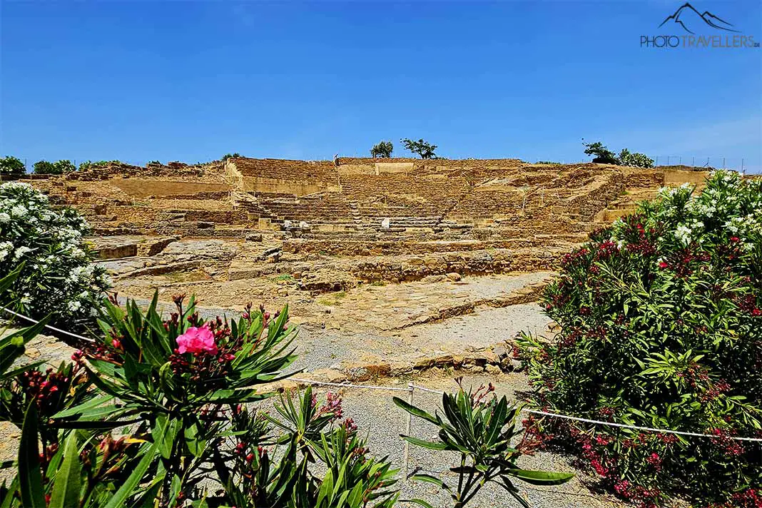 Blumensträucher umranken die Steintreppen des historischen Amphitheater in Hephaista