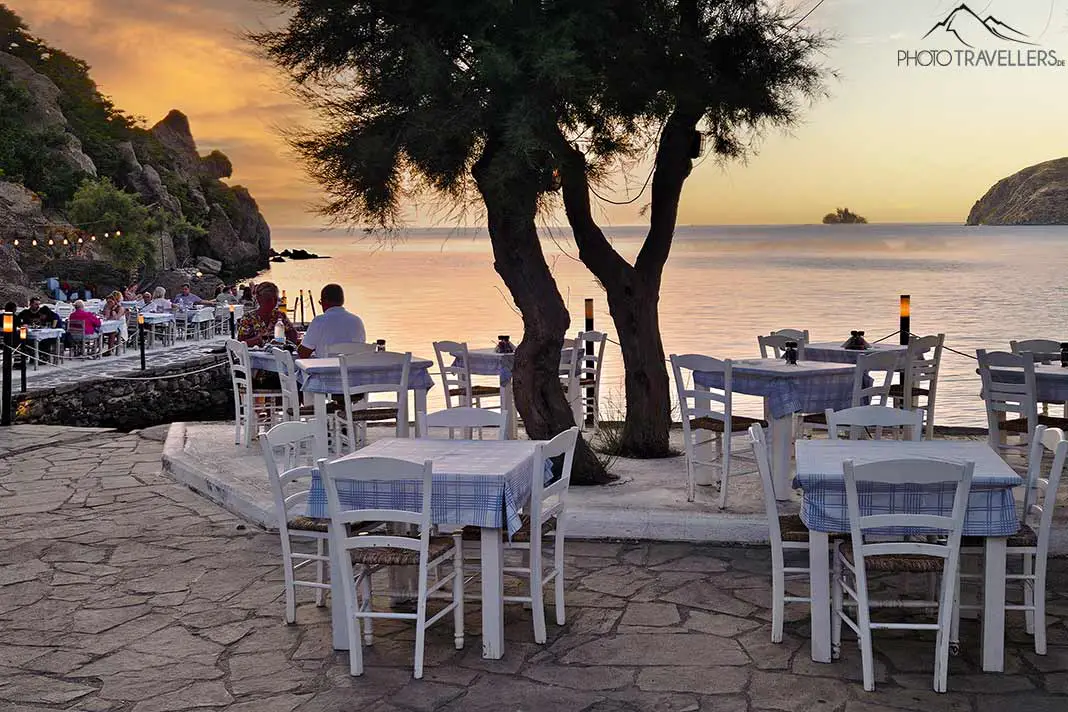 Die Gäste einer Taverne genießen den Sonnenuntergang am Meer auf Limnos