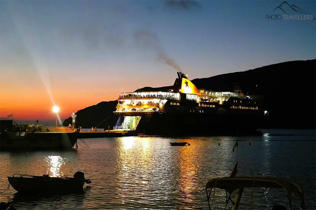 Eine große Fähre legt im Abendrot im Hafen von Kamares an