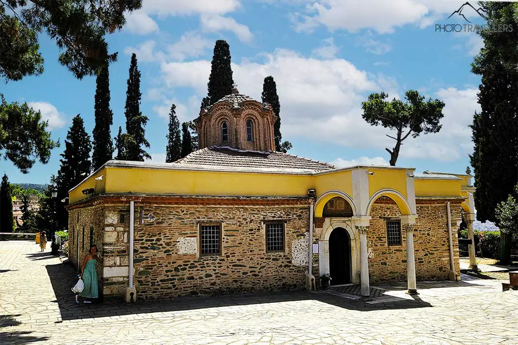 Das historische Vlatades-Kloster in Thessaloniki mit seiner Sandstein-Fassade ist eingebettet von Zypressen