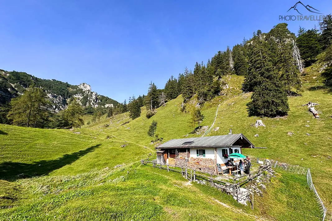 Die Brandlbergalm inmitten grüner Wiesen und der Berge