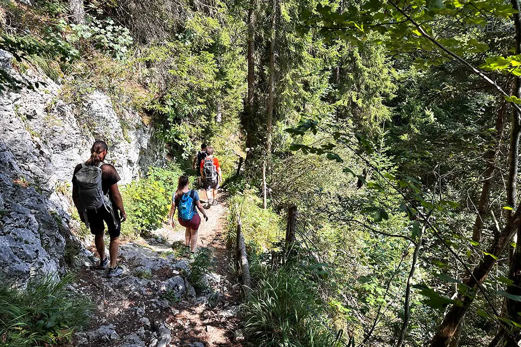 Mehrere Wanderer auf einem felsigen Stück des Abstiegs vom Spitzstein