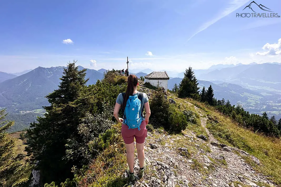 Reisebloggerin Biggi Bauer am Spitzsteingipfel, dahinter die Kapelle und das Gipfelkreuz