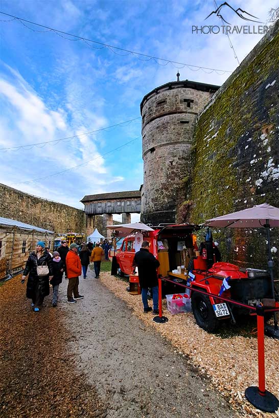 Rund um die steinernen Schutztürme und Mauern der Festung Rosenberg schlendern Besucher entlang der Weihnachtsstände