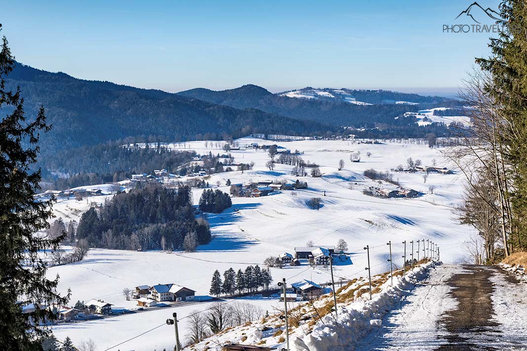 Der Blick vom Wanderweg auf dem Schwarzenberg ins verschneite Alpenvorland