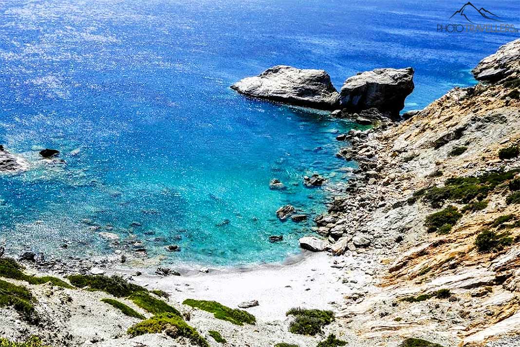 In einer kleinen Bucht liegt der Ammoudi Beach mit einigen Felsen davor im Meer