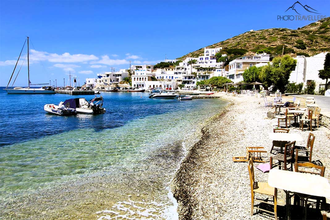 Stühle einer Taverne in Katapola reichen bis ans Meer mit einigen kleinen Motorbooten 