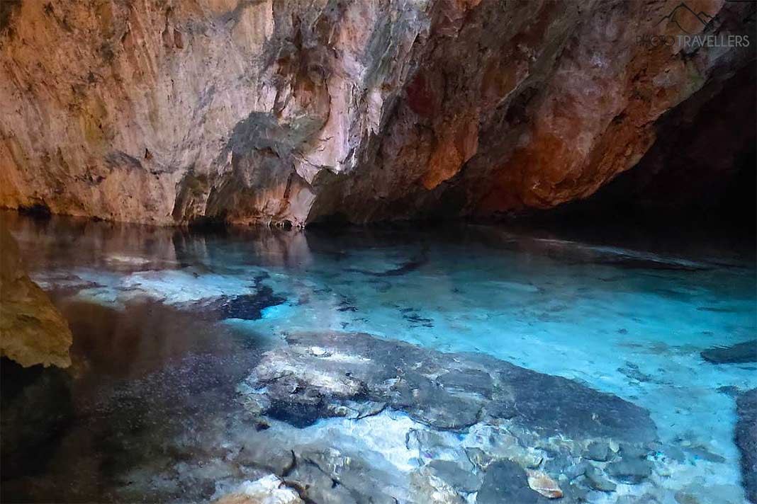 Türkisblaues Wasser bildet einen schönen Kontrast zu den rotbraunen Felsen in der Peristeri-Höhle