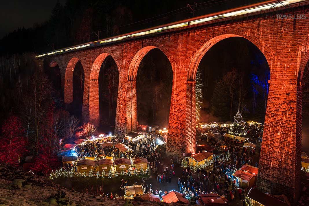 Der Blick über den Weihnachtsmarkt in der Ravennaschlucht mit der rot beleuchteten Brücke