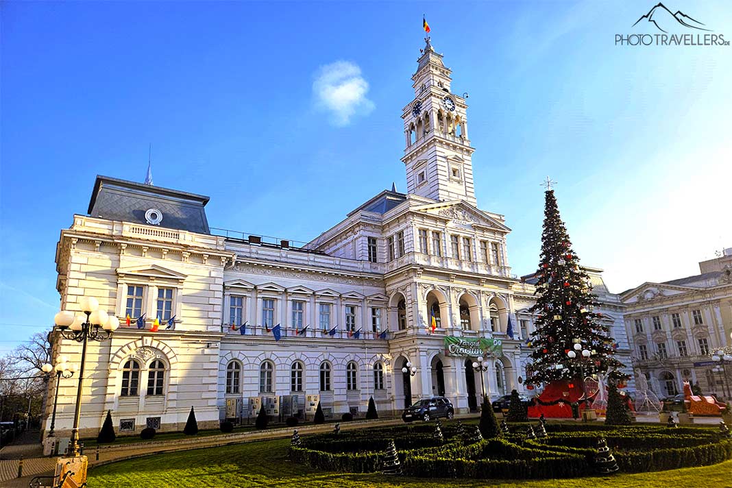 Der zweistöckige Verwaltungspalast mit dem hohen Kirchturm mit einer Tanne davor