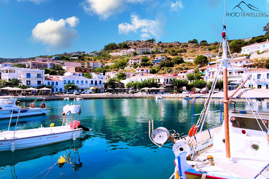 Kleine Boote ankern in der Marina von Evdilos mit weißen Häusern dahinter