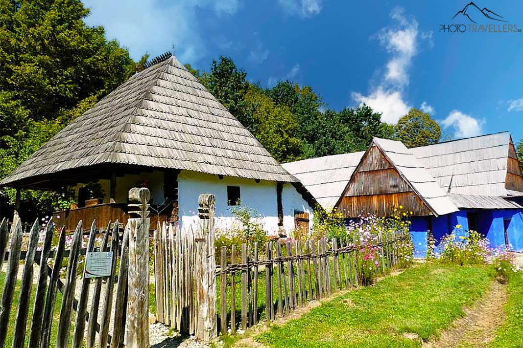 Alte Holzhäuser mit historischen Zäunen reihen sich im ASTRA-Museum in Sibiu aneinander